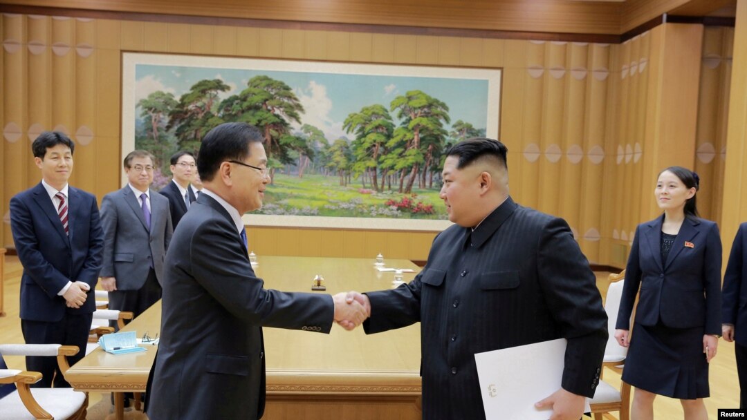 Pemimpin Korea Utara Kim Jong Un berjabat tangan dengan Chung Eui-yong yang memimpin delegasi Korea Selatan, dalam foto yang dirilis kantor berita pemerintah Korea Utara (KCNA), 6 Maret 2018.