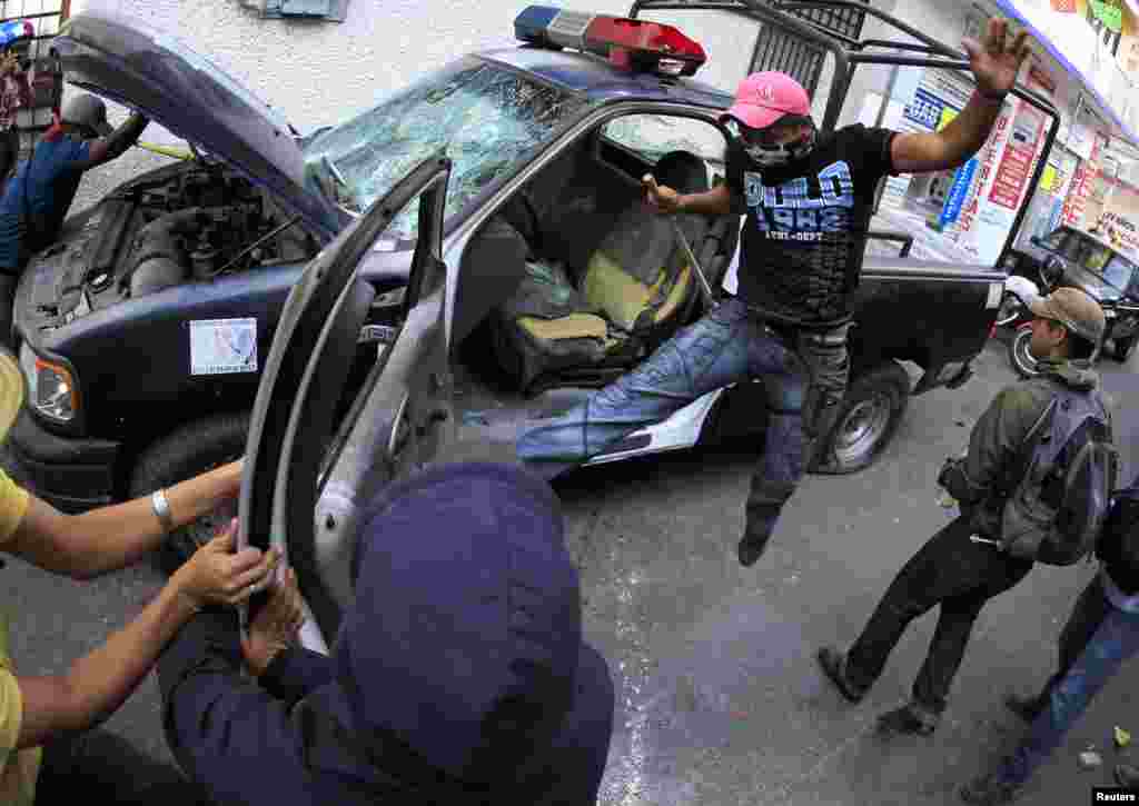 Demonstrators destroy a police patrol vehicle during a protest by relatives of the 43 missing students from the Ayotzinapa Teacher Training College outside the federal court in Chilpancingo, in the Mexican state of Guerrero, Jan. 19, 2015. The protest was held to urge the federal court to bring charges of disappearance and murder against the former mayor of Iguala, Jose Luis Abarca, and his wife Maria de los Angeles Pineda Villa, for the massacre of the 43 Ayotzinapa Teacher Training College students in Sept. 2014.