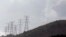 FILE - Electricity pylons snake across a hill in a Johannesburg suburb.