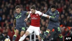 Gelandang Arsenal, Aaron Ramsey (tengah), menahan pemain depan Sporting asal Argentina, Marcos Acuna (kanan) saat penyisihan grup Piala UEFA antara Arsenal dan Sporting Lisbon di Stadion Emirates, London, 8 November 2018.