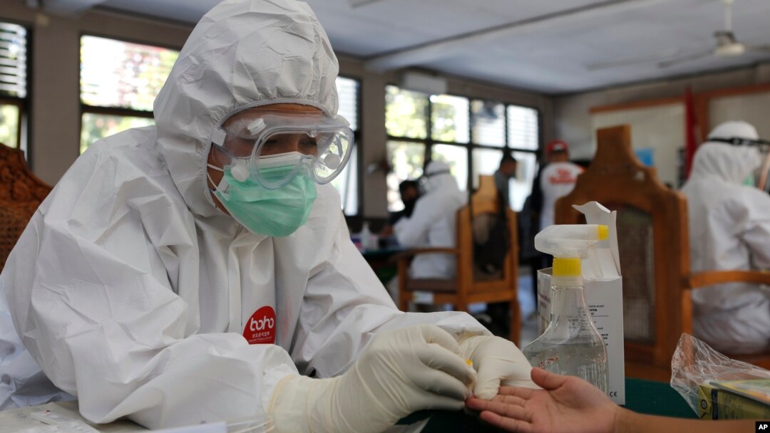 Seorang nakes (tenaga kesehatan) melakukan tes antibodi Covid-19 di sebuah kantor di Bali, Jumat, 11 September 2020. (AP Photo / Firdia Lisnawati)