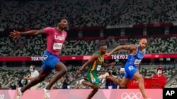Lamont Jacobs, right, of Italy, wins the men's the 100-meter final at the 2020 Summer Olympics, Aug. 1, 2021, in Tokyo.