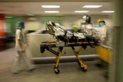 Medical staff move a COVID-19 patient at the CHR Citadelle hospital in Liege, Belgium, Oct. 21, 2020.