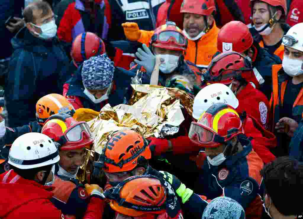 Elif Perincek, a three-year-old survivor, holds the thumb of a rescue worker as she is rescued from the rubble of a building some 65 hours after a magnitude 6.6 earthquake in Izmir, Turkey. (Istanbul Fire Authority/Handout)