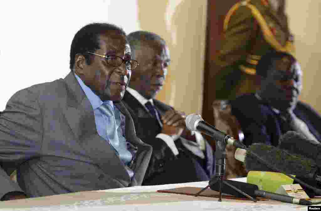 Zimbabwe&#39;s President Robert Mugabe (L) addresses the media as South Africa&#39;s President Thabo Mbeki (C) and leader of Zimbabwe&#39;s main opposition Movement for Democratic Change (MDC) Morgan Tsvangirai listen at Harare&#39;s Rainbow Towers Hotel July 21, 2008.