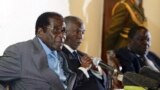 Zimbabwe&#39;s President Robert Mugabe (L) addresses the media as South Africa&#39;s President Thabo Mbeki (C) and leader of Zimbabwe&#39;s main opposition Movement for Democratic Change (MDC) Morgan Tsvangirai listen at Harare&#39;s Rainbow Towers Hotel July 21, 2008.