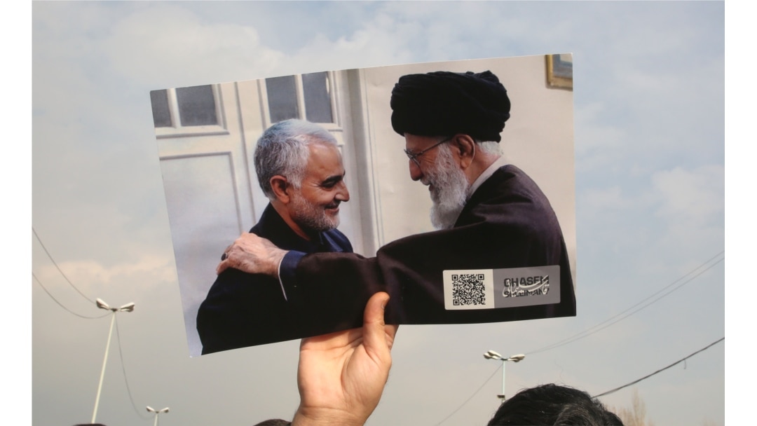 A man holds a picture of Iran's supreme leader Ali Khamenei with Iranian Revolutionary Guards top commander Qasem Soleimani (L) during a demonstration in Tehran, Jan. 3, 2020 against the killing of the top commander in a US strike in Baghdad.