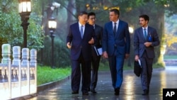 Visiting Spanish Prime Minister Pedro Sanchez, second right, chats with Chinese President Xi Jinping, left, as they tour the Diaoyutai State Guesthouse in Beijing, Sept. 9, 2024. (Xinhua via AP)