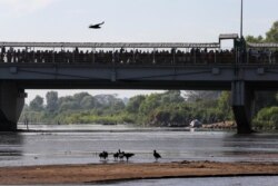 Migrants crowd the the bridge spanning the Suchiate River on the border between Guatemala and Mexico in Ciudad Hidalgo, Jan. 18, 2020.