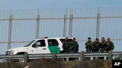 Agentes de la Patrulla Fronteriza de Estados Unidos frente a una valla secundaria en San Diego, California, observan el otro lado de la frontera mientras responden a un grupo de migrantes centroamericanos que cruzaron la frontera ilegalmente en Tijuana, México. 9 Dic.2018.