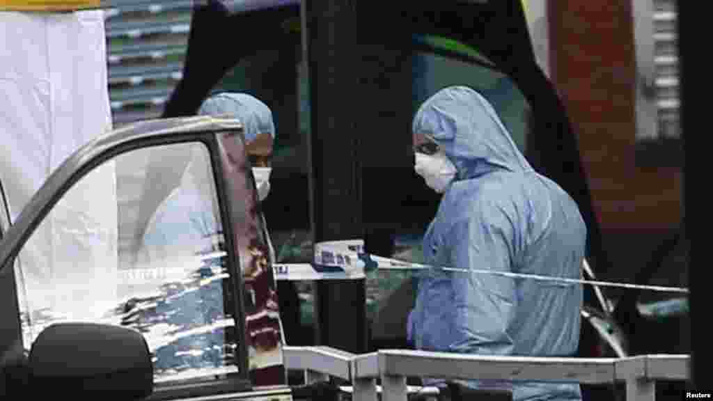 Police forensics officers investigate a car at a crime scene where one man was killed in Woolwich, southeast London May 22, 2013.