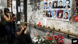 FILE - Women react in the gym of the ruined school, scene of the hostage crisis, in Beslan, Russia, Sept. 1, 2009. 