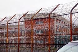 FILE - In this March 16, 2011, file photo, a security fence surrounds inmate housing on the Rikers Island correctional facility in New York.