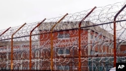 FILE - In this March 16, 2011, file photo, a security fence surrounds inmate housing on the Rikers Island correctional facility in New York. New York City lawmakers are considering a plan to close the notorious Rikers Island jail complex and replace it…