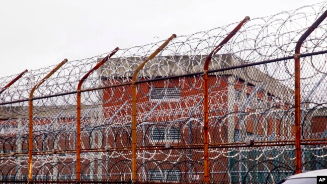 FILE - In this March 16, 2011, file photo, a security fence surrounds inmate housing on the Rikers Island correctional facility in New York. New York City lawmakers are considering a plan to close the notorious Rikers Island jail complex and replace it…