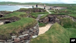 FILE - Visitors look at the ancient remains of Skara Brae village in the Scottish Orkney Islands, July 19, 2005. Officials on Scotland’s Orkney Islands are considering options for “alternative models of governance."( AP Photo/Naomi Koppel, File)