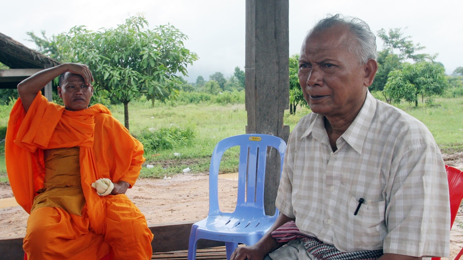 FILE - Meas Muth, right, sits next to a Buddhist monk at Anlong Veng district in Oddar Mean Chey province, Cambodia, July 23, 2006. Meas Muth was implicated in the 1975 Mayaguez incident in which at least 38 U.S. servicemen died.