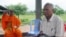 FILE - Meas Muth, right, sits next to a Buddhist monk at Anlong Veng district in Oddar Mean Chey province, Cambodia, July 23, 2006. Meas Muth was implicated in the 1975 Mayaguez incident in which at least 38 U.S. servicemen died.