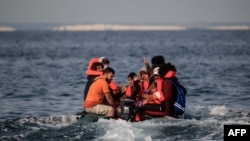 Des migrants réagissent à l'approche de la côte sud de la Grande-Bretagne alors qu'ils traversent illégalement la Manche depuis la France.