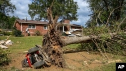 An overturned tractor lies next to an uprooted tree on the White family' property in the aftermath of Hurricane Helene, in Morganton, North Carolina, Oct. 1, 2024.