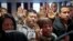 Inmigrantes alzan su mano para prestar juramento como nuevos ciudadanos estadounidenses en Nueva York.