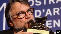 Guillermo del Toro kisses the Golden Lion for best film for "The Shape Of Water" during the awards photo call at the 74th Venice Film Festival at the Venice Lido, Italy, Sept. 9, 2017.