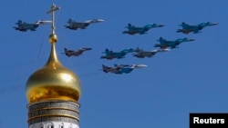 Military jets fly over an Orthodox Christian church during a rehearsal for the Victory Day parade in Moscow, May 7, 2013. 