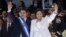 Honduras' President Juan Orlando Hernandez, left, and his wife Ana Rosalinda wave after his swearing in ceremony as new president in Tegucigalpa, Honduras, Jan. 27, 2014.