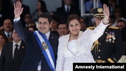 FILE - Honduras' President Juan Orlando Hernandez, left, and his wife Ana Rosalinda wave after his swearing in ceremony as new president in Tegucigalpa, Honduras, Jan. 27, 2014.