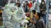 A medical worker takes a swab sample from a resident to be tested for the COVID-19 in Wuhan in China's central Hubei province. Nervous residents queued up across the city for testing after a new cluster of cases sparked a mass screening campaign.