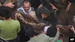 In this image taken from video, people carry a child's body pulled out from rubble following Saudi-led coalition airstrikes that killed dozens, including children, in the residential center of the capital, Sanaa, Yemen, May 16, 2019.