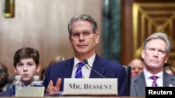 FILE - Scott Bessent, U.S. President-elect Donald Trump's nominee to be secretary of treasury, looks on next to his husband John Freeman and son Cole, on the day he testifies during a Senate Committee on Finance confirmation hearing on Capitol Hill in Washington, Jan. 16, 2025. 