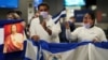 Activistas esperan la llegada de algunos de los más de 200 presos políticos de Nicaragua al Aeropuerto Internacional Dulles en Virginia, en las afueras de Washington, EE. UU., luego de ser liberados y trasladados a Estados Unidos el 9 de febrero de 2023. REUTERS/Kevin Lamarque