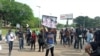 FILE - A female protester holds up a placard reading "End SARS" during protests at the popular Berger junction in Abuja, Nigeria, Oct. 14, 2020. (Timothy Obiezu/VOA)