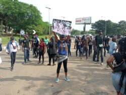 A female protester holds up a placard reading 'End SARS' during continued protests at the popular Berger junction in Abuja, Oct. 14, 2020. (Timothy Obiezu/VOA)
