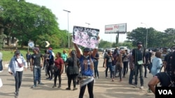 FILE - A female protester holds up a placard reading "End SARS" during protests at the popular Berger junction in Abuja, Nigeria, Oct. 14, 2020. (Timothy Obiezu/VOA)