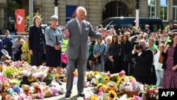 Britain's King Charles III reacts as he views tributes outside Southport Town Hall during his visit to meet with members of the community following the July 29 attack at a children's dance party in Southport, U.K., on Aug. 20, 2024.