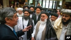 FILE - Russian presidential envoy to Afghanistan Zamir Kabulov, left, speaks with Taliban representatives prior to their talks in Moscow, May 28, 2019.
