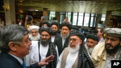 FILE - Russian envoy to Afghanistan Zamir Kabulov, left, speaks with Taliban representatives prior to their talks in Moscow, May 28, 2019.