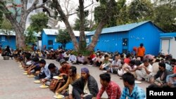 Daily wage workers and homeless people eat food inside a government-run night shelter during a 21-day nationwide lockdown to limit the spreading of coronavirus disease (COVID-19), in the old quarters of Delhi, India, March 26, 2020. 