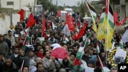 Palestinian mourners carry the body of Palestinian woman Jawaher Abu Rahmeh, 36, during her funeral in the West Bank village of Bilin near Ramallah, 01 Jan 2011