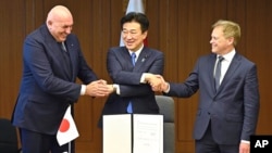 Britain's Defense Minister Grant Shapps, right, Italy's Defense Minister Guido Crosetto, left, and Japanese Defense Minister Minoru Kihara, center, shake hands after a signing ceremony for Global Combat Air Programme at the defense ministry Dec. 14, 2023, in Tokyo, Japan. 
