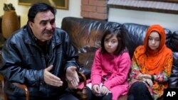 In this Nov. 29, 2018 photo, Mir Aman speaks to The Associated Press with his daughters Shahnaz, right, and Shakeela, in Islamabad, Pakistan.