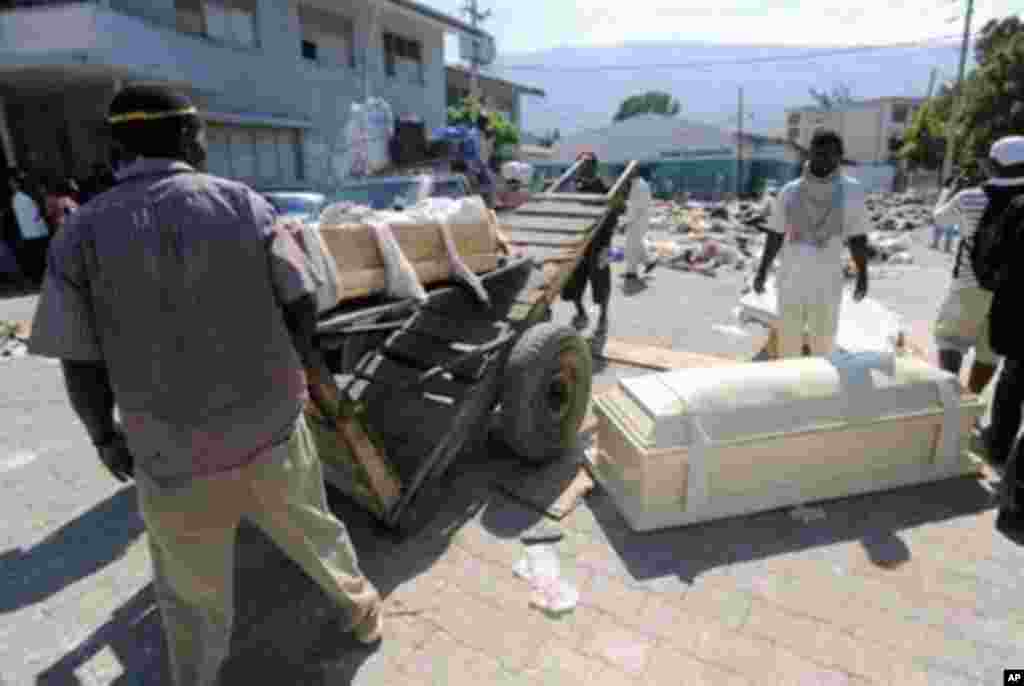 Locals carry coffins outside the morgue in Port-au-Prince on January 15, 2010. Despairing Haitians clawed by hand to seek survivors in the rubble of their homes as frustration grew at the trickle of aid Friday after a quake the Red Cross said may have kil