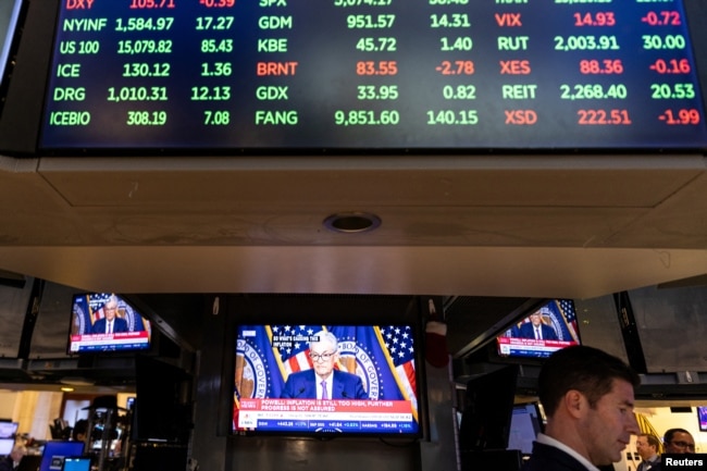 FILE - A trader works inside a booth, as screens display a news conference by Federal Reserve Board Chairman Jerome Powell following the Fed rate announcement, on the floor of the New York Stock Exchange (NYSE) in New York City, U.S., May 1, 2024. (REUTERS/Stefan Jeremiah)