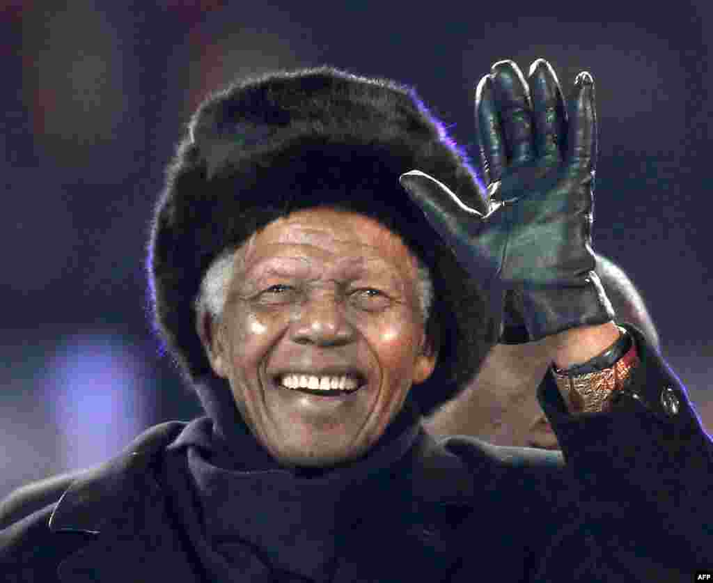 Nelson Mandela waves as he arrives to attend the 2010 World Cup football final Netherlands vs. Spain on July 11, 2010 at Soccer City stadium in Soweto.