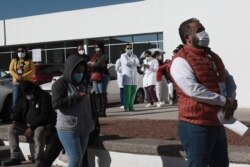 FILE - Health care workers wait in line outside General Hospital to receive the Pfizer COVID-19, on the first day of coronavirus vaccinations in Ciudad Juarez, Mexico, Jan. 13, 2021. (AP Photo/Christian Chavez)