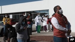 Health care workers wait in line outside General Hospital to receive the Pfizer COVID-19, on the first day of coronavirus vaccinations in Ciudad Juarez, Mexico, Jan. 13, 2021.