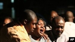 A woman who lost a relative in a bomb explosion, center, mourns at the Asokoro General Hospital, Abuja, Nigeria, Friday, Dec. 31, 2010.