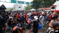 Migrants attempt to cross the border from Corinto, Honduras, into Corinto, Guatemala, Oct. 1, 2020. 